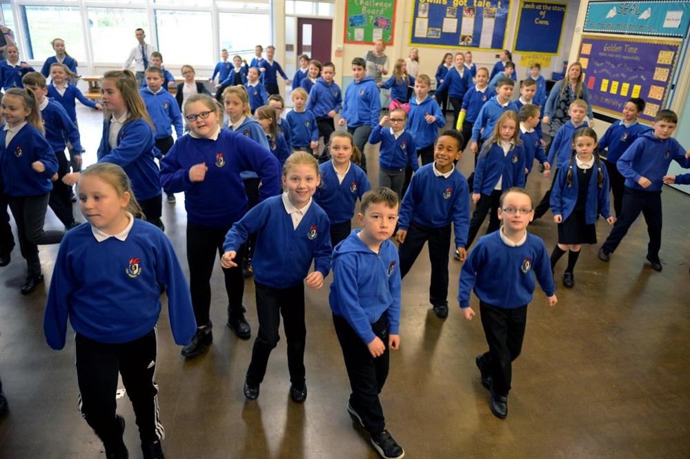 Pupils dancing together in the school hall